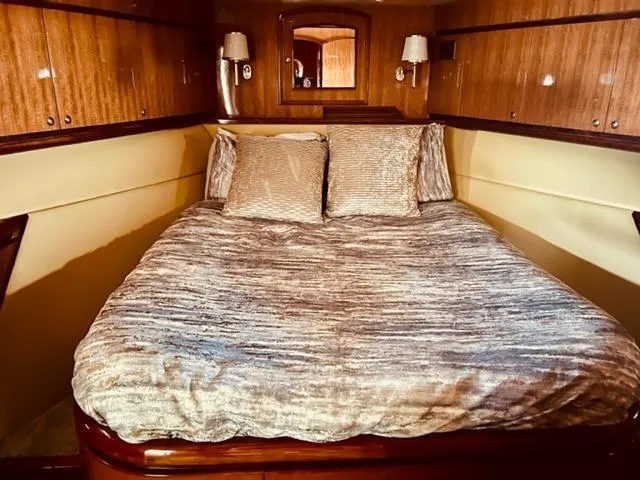 Slide: The Image of Luxurious bedroom in 2008 Hampton Command Bridge yacht with plush bedding and wooden cabinetry. - 9