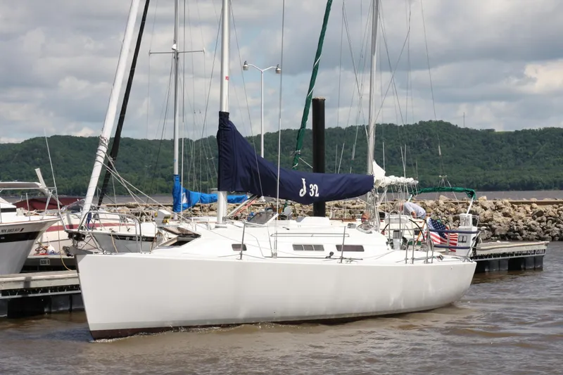 Slide: The Image of 2001 J Boats 32 sailboat docked at a marina with scenic background. - 16