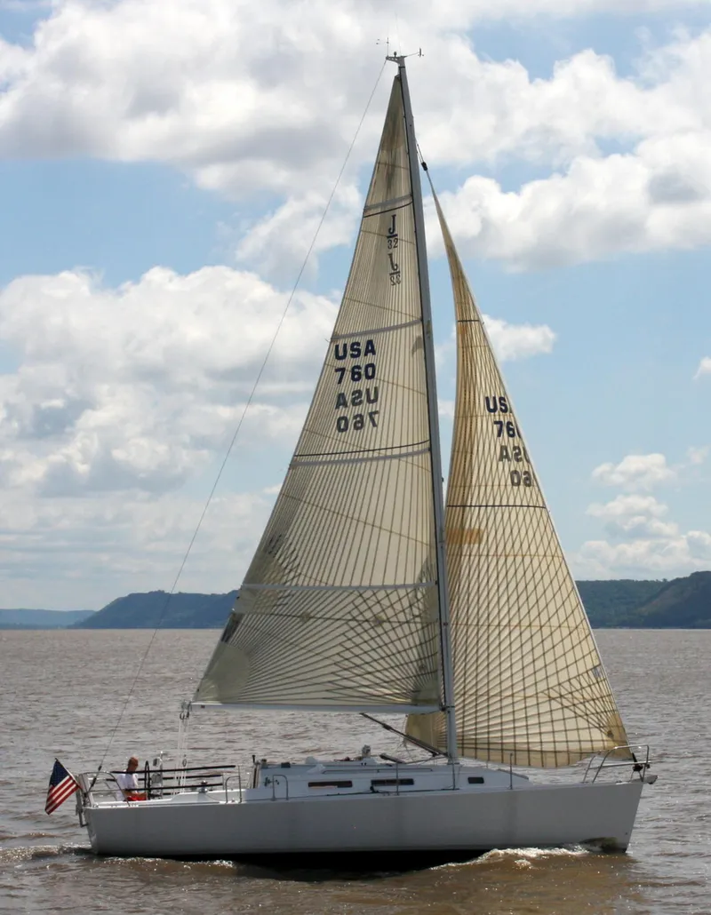Slide: The Image of 2001 J Boats 32 sailing on a calm lake under a partly cloudy sky. - 17