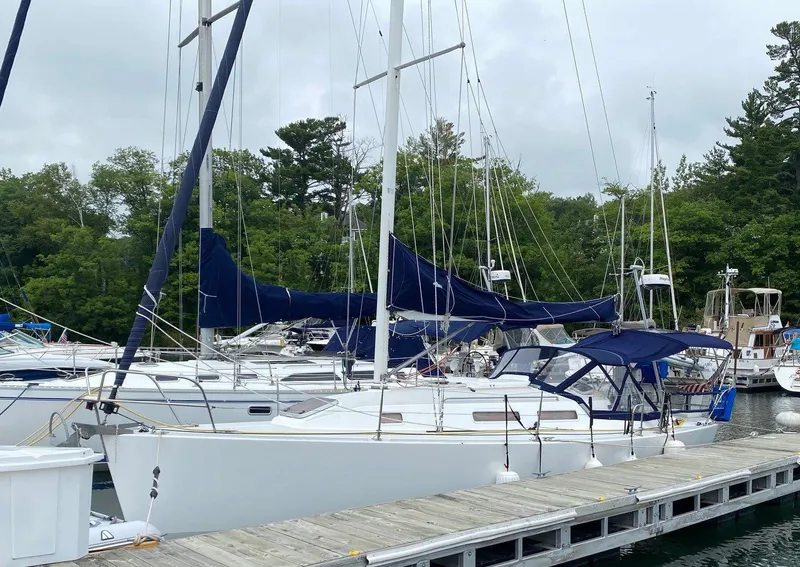 Slide: The Image of Sailboat docked at marina, J Boats 32, 2001 model, with blue covers. - 2