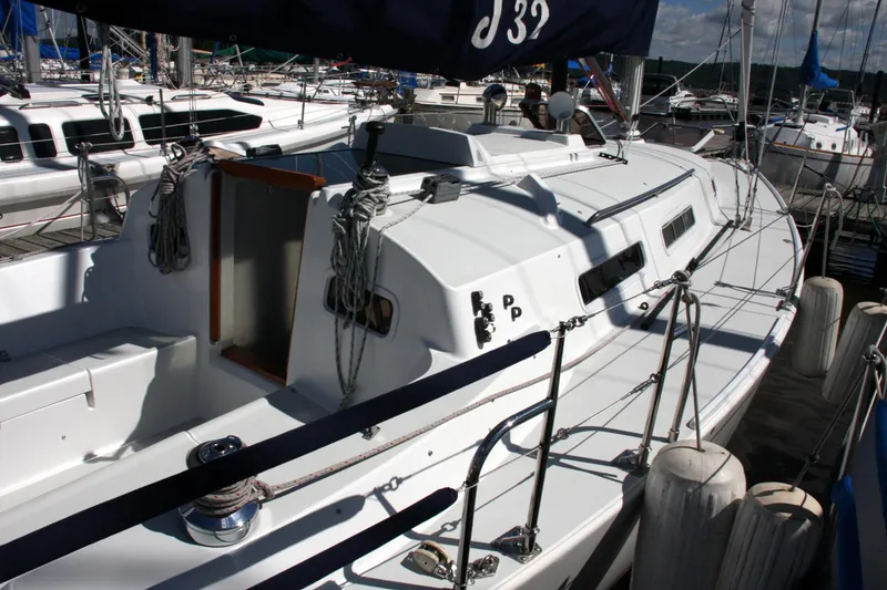 Slide: The Image of 2001 J Boats 32 sailboat docked at marina, featuring sleek white design and rigging. - 27