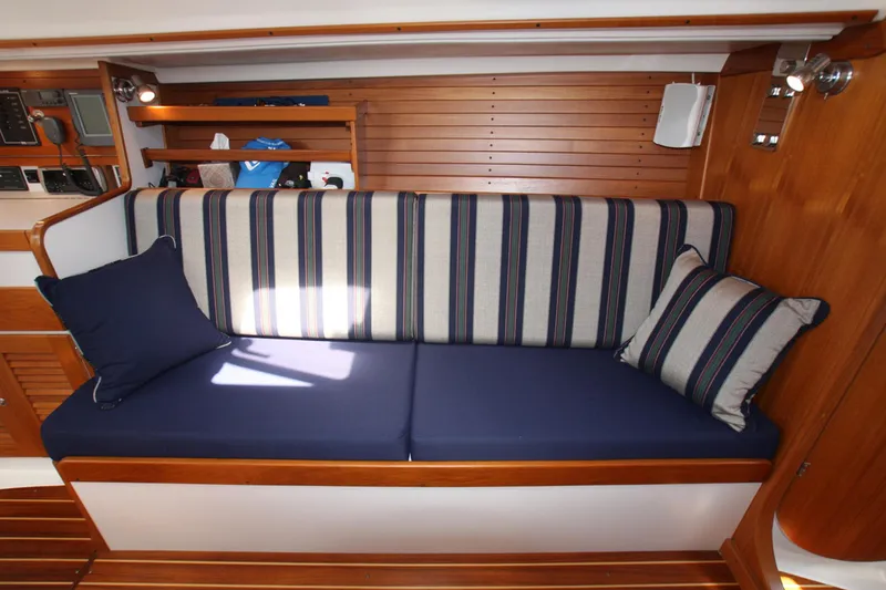 Slide: The Image of 2001 J Boats 32 interior with striped cushions and wooden paneling. - 3
