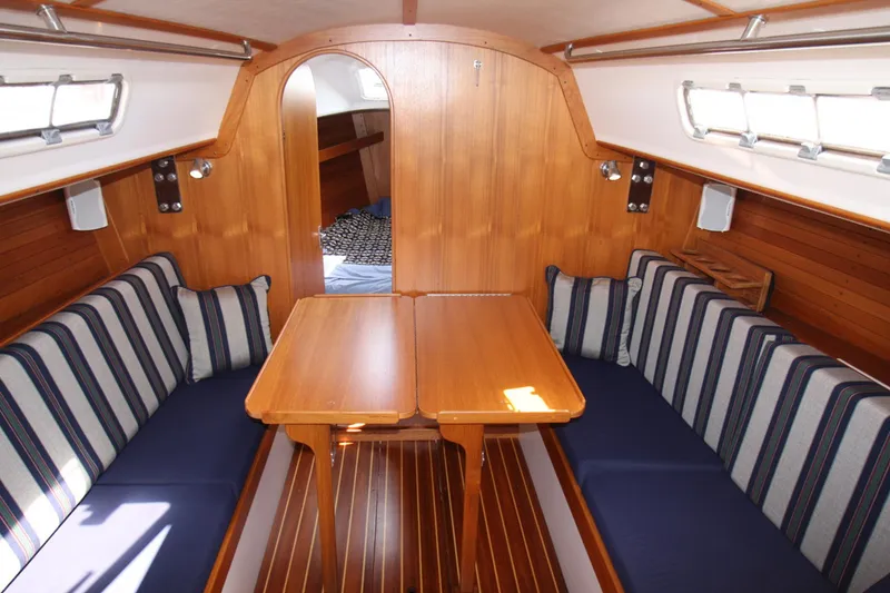 Slide: The Image of Cozy interior of a 2001 J Boats 32 sailboat with striped seating and wooden finishes. - 33