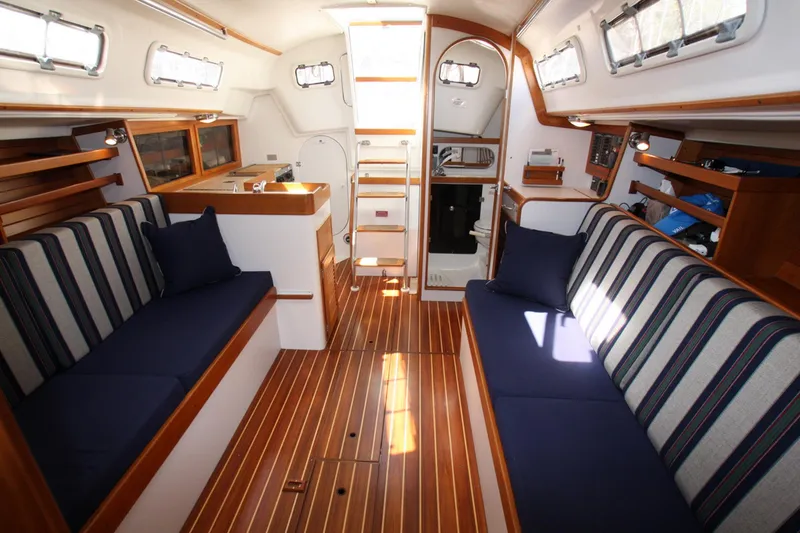 Slide: The Image of Interior of 2001 J Boats 32 sailboat with striped seating and wooden flooring. - 6