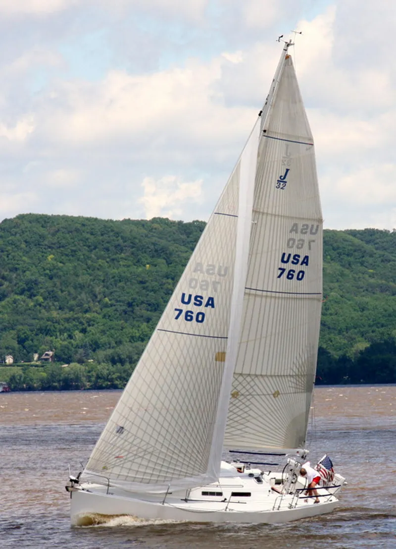 Slide: The Image of 2001 J Boats 32 sailing on a river with lush green hills. - 7