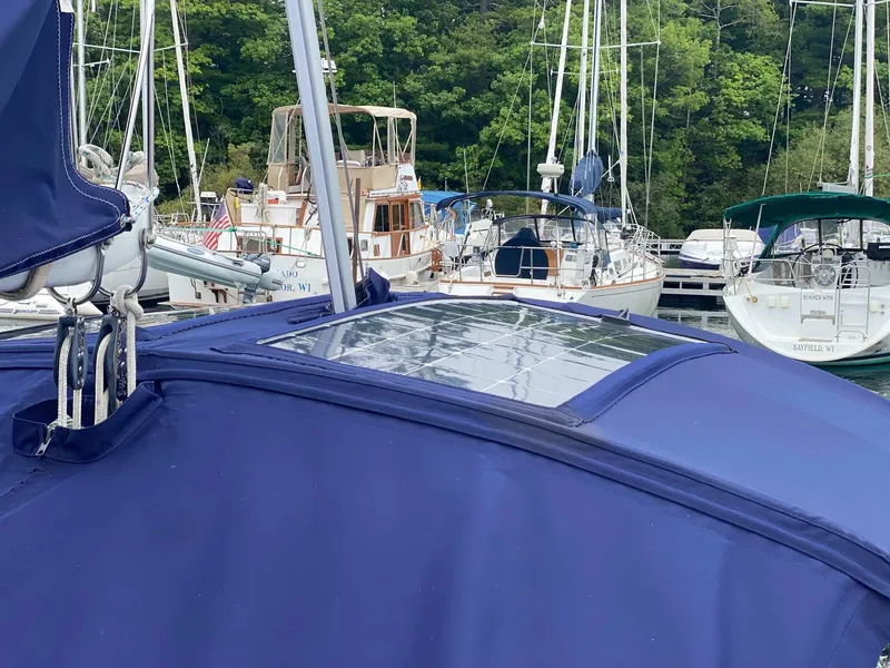 Slide: The Image of 2001 J Boats 32 sailboat with blue cover docked among other boats. - 9