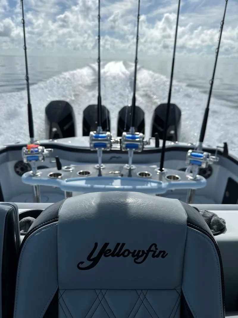 Slide: The Image of 2022 Yellowfin 39 boat with multiple fishing rods and engines on a calm sea. - 11