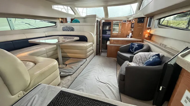 Slide: The Image of Interior of 2002 Regal Commodore 3880 yacht with seating area and dining table. - 15