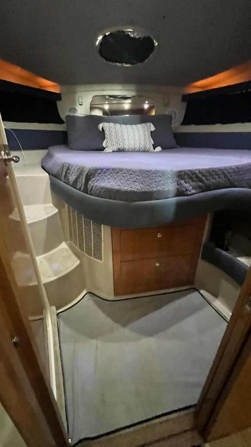 Slide: The Image of 2002 Regal Commodore 3880 cabin with bed, storage, and steps. - 26