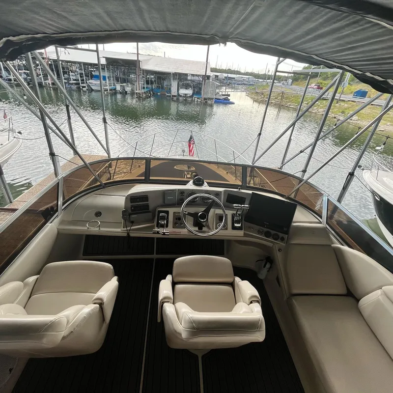 Slide: The Image of 2002 Regal Commodore 3880 yacht cockpit with helm, seating, and marina view. - 8