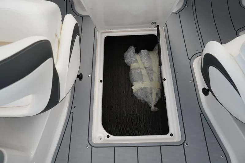 Slide: The Image of 2024 Chaparral 23 SSi OB boat storage compartment with wrapped items inside. - 16