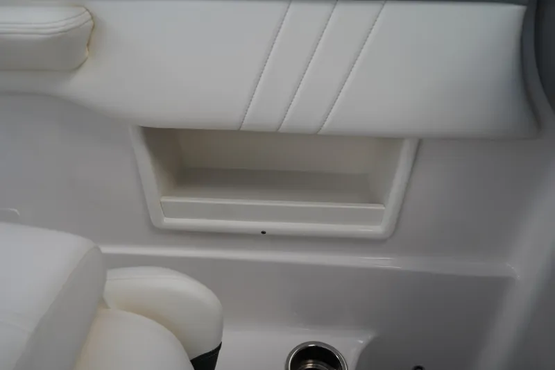 Slide: The Image of 2024 Chaparral 23 SSi OB interior detail with white seating and storage compartment. - 19