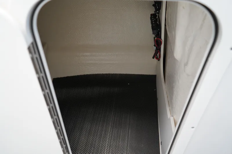 Slide: The Image of 2024 Chaparral 23 SSi OB boat storage compartment with black flooring. - 30