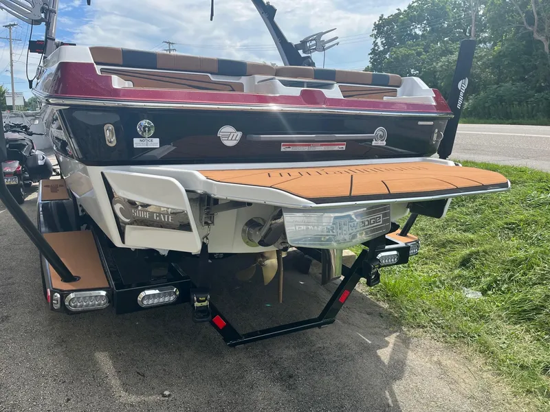 Slide: The Image of 2024 Malibu 21 LX boat rear view with swim platform and wakeboard tower. - 3