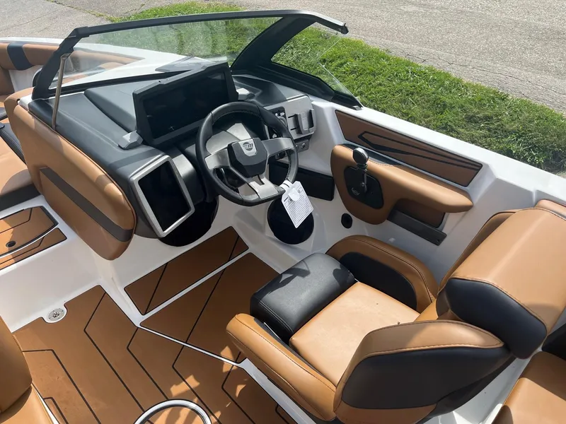 Slide: The Image of 2024 Malibu 21 LX boat interior with modern dashboard and tan seating. - 5