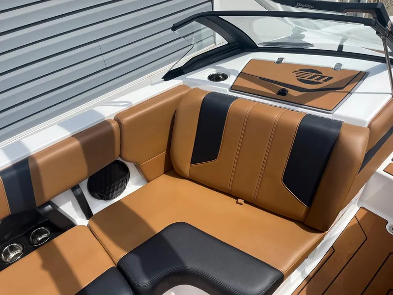 Slide: The Image of 2024 Malibu 21 LX boat interior with tan and black seating. - 6