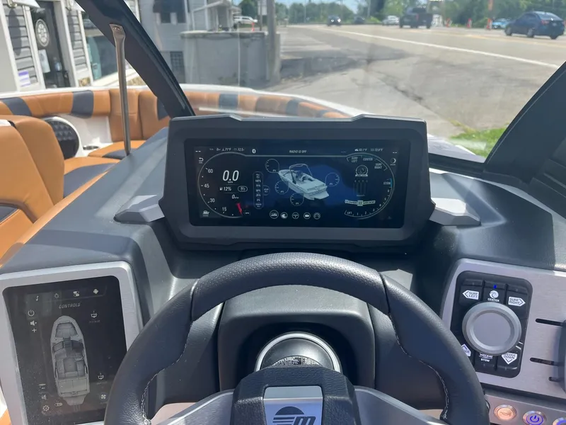 Slide: The Image of 2024 Malibu 21 LX boat dashboard with digital display and controls. - 8