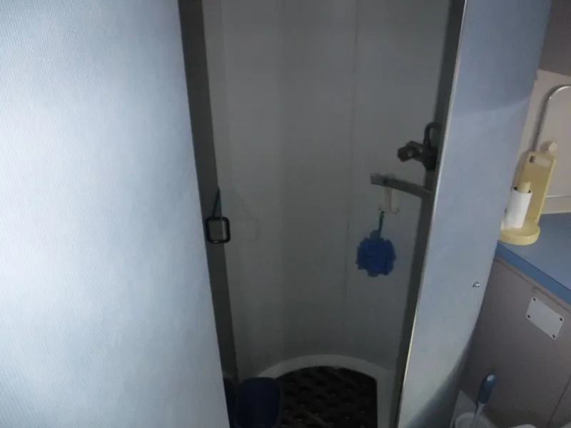 Slide: The Image of Shower area inside a 1988 Trojan 12 Meter boat, featuring compact design and amenities. - 17