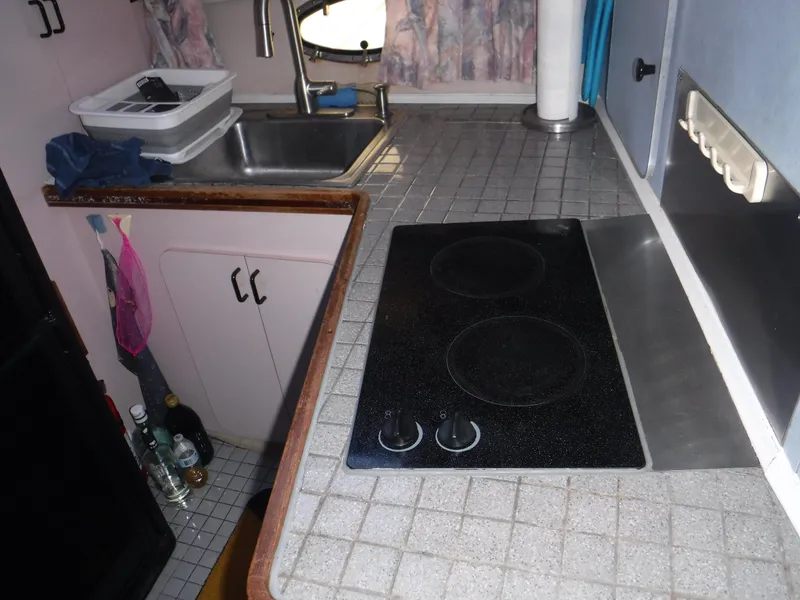 Slide: The Image of 1988 Trojan 12 Meter yacht kitchen with stove, sink, and tiled countertop. - 23