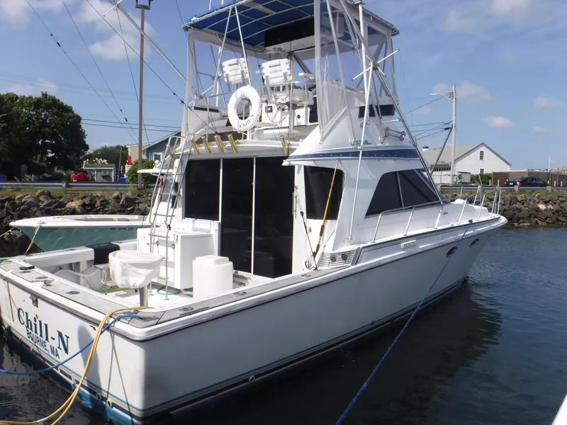 Slide: The Image of 1988 Trojan 12 Meter yacht docked, featuring a spacious deck and flybridge. - 26