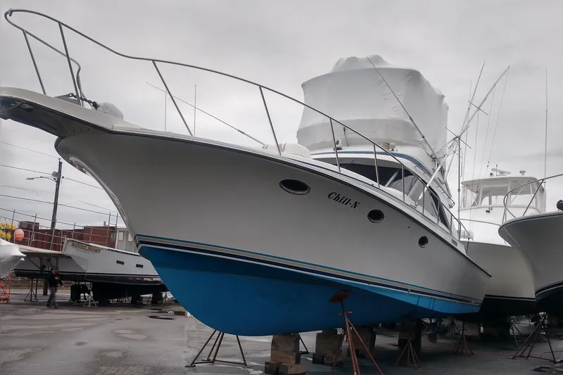 Slide: The Image of 1988 Trojan 12 Meter boat with blue hull, docked on land. - 3