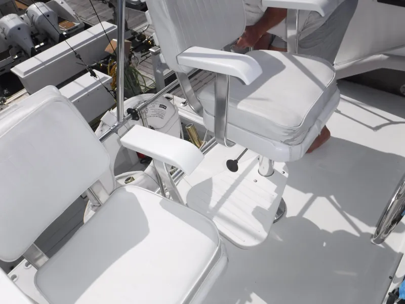 Slide: The Image of White seating on 1988 Trojan 12 Meter boat deck, featuring armrests and pedestal mounts. - 41