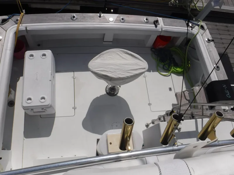 Slide: The Image of 1988 Trojan 12 Meter boat deck with fishing chair, cooler, and rod holders. - 42