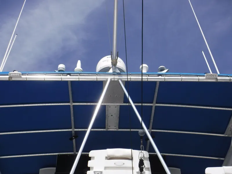 Slide: The Image of 1988 Trojan 12 Meter boat with blue canopy and radar equipment against a clear sky. - 43