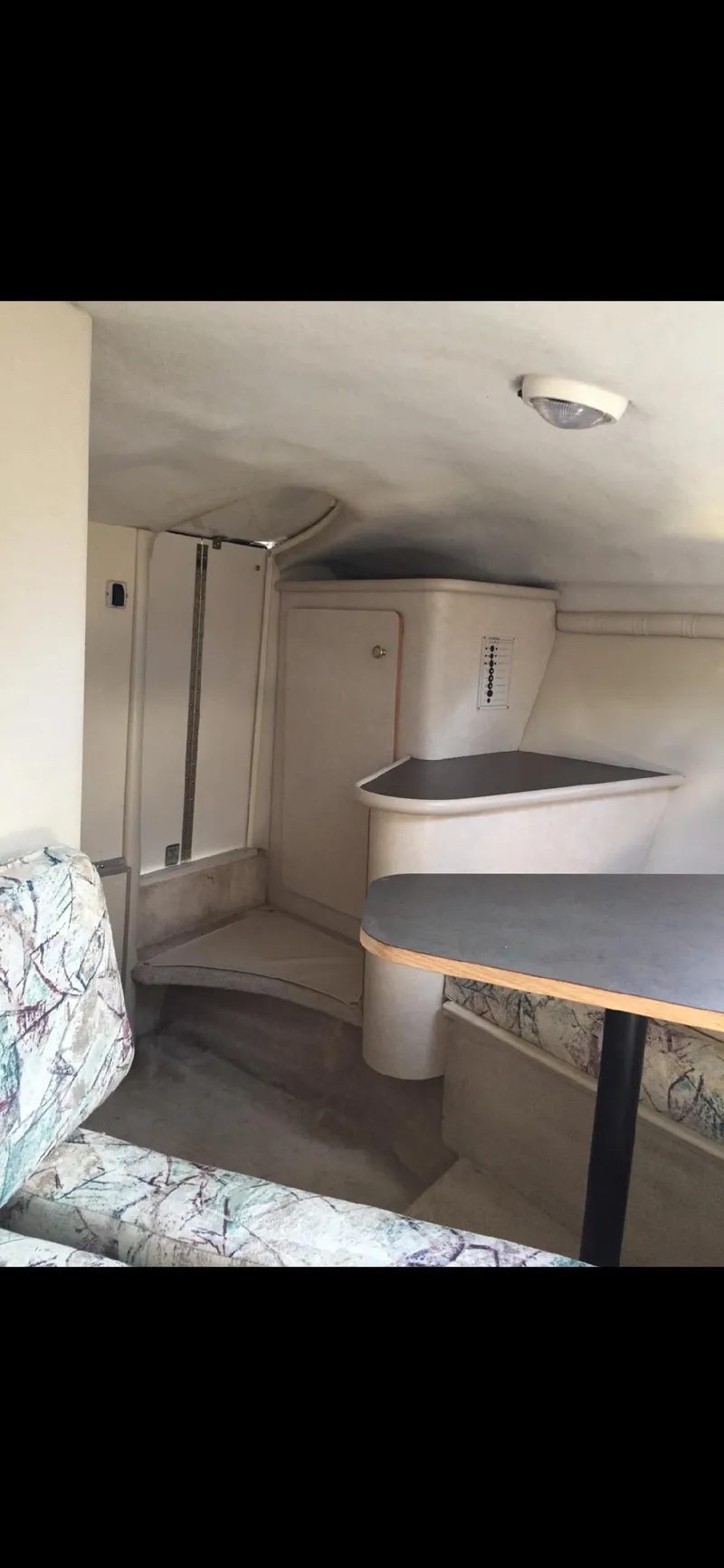 Slide: The Image of 1997 Regal Ventura 8.3 SC cabin interior with seating and compact kitchenette. - 11