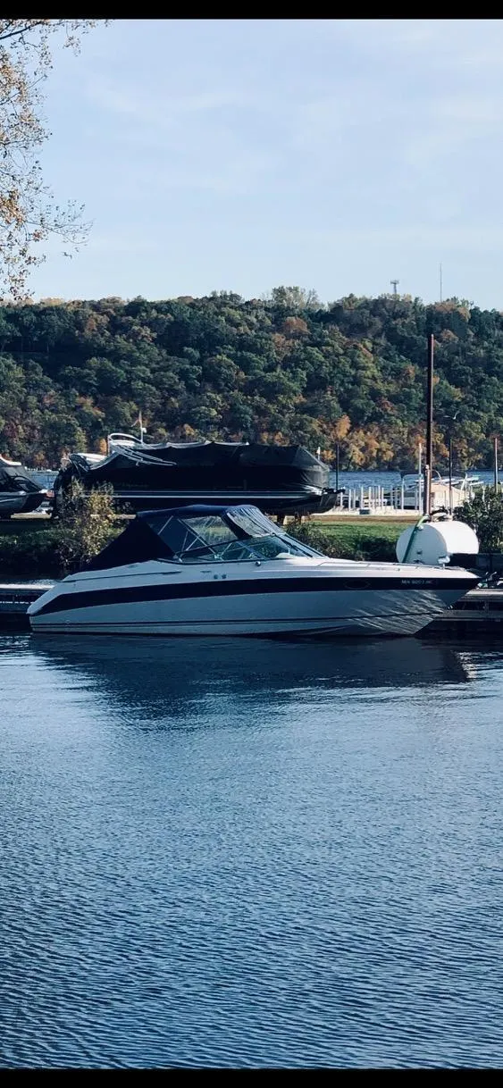 Slide: The Image of 1997 Regal Ventura 8.3 SC boat docked on a calm lake with scenic background. - 13
