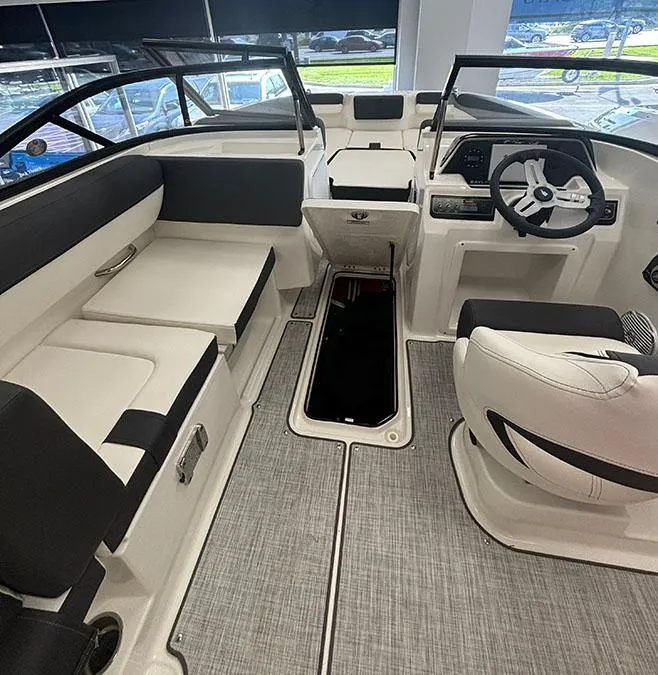Slide: The Image of 2024 Bayliner DX 2050 boat interior with seating, steering wheel, and storage compartment. - 10