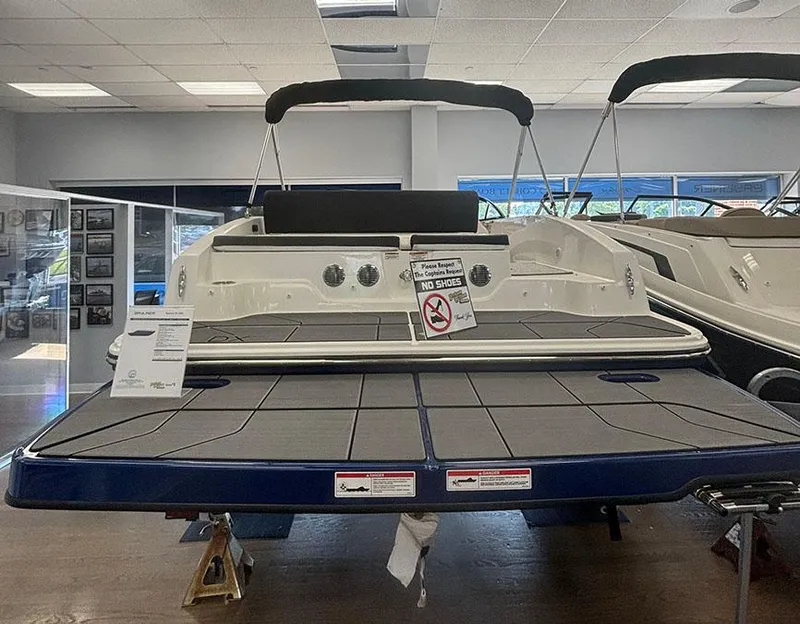 Slide: The Image of 2024 Bayliner DX 2050 boat displayed indoors, rear view with swim platform. - 2