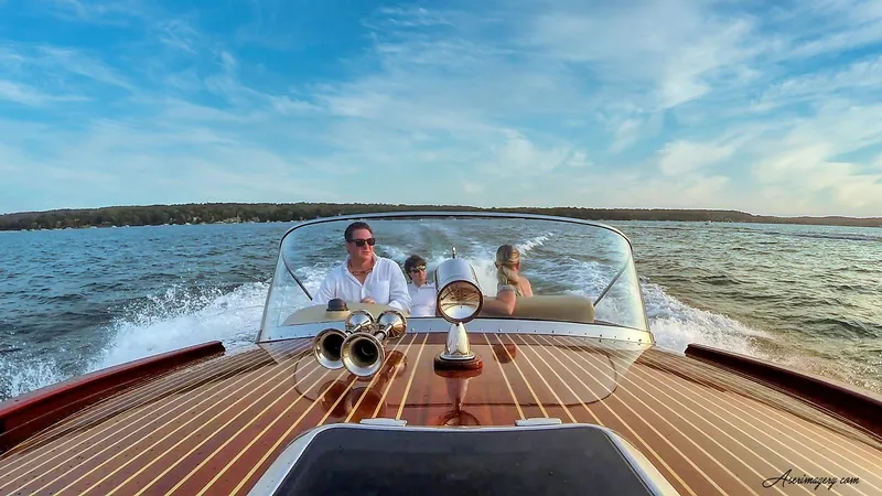 Slide: The Image of A 2020 Custom Windlea Runabout boat cruising on a lake with passengers enjoying the ride. - 11