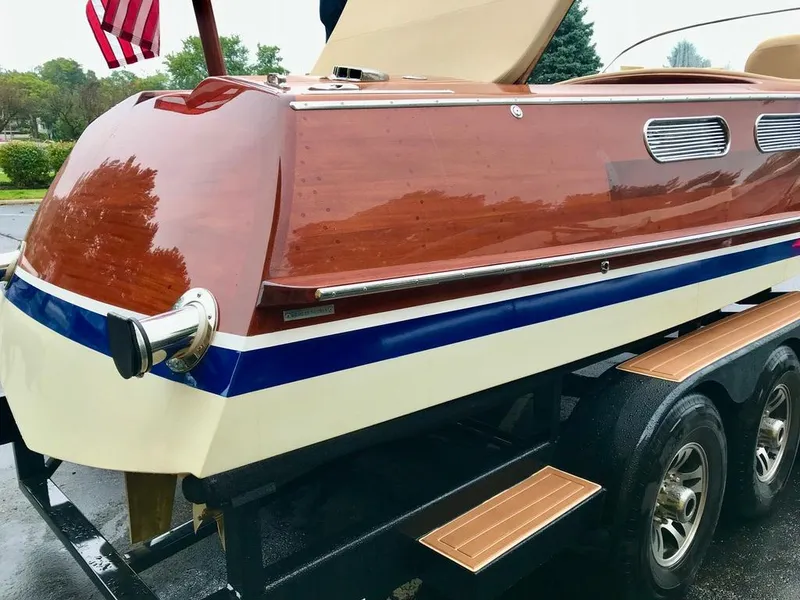 Slide: The Image of Custom 2020 Windlea Runabout boat on trailer, featuring sleek wooden design and American flag. - 38