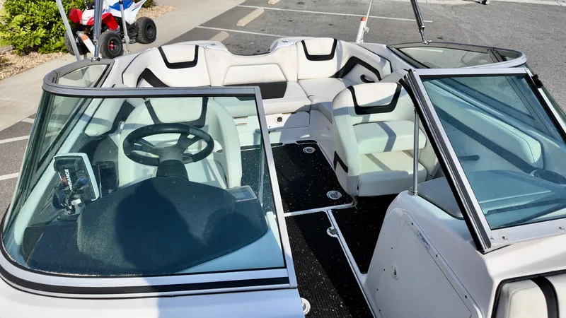 Slide: The Image of 2015 Yamaha Boats SX190 interior with steering wheel and seating, parked outdoors. - 10