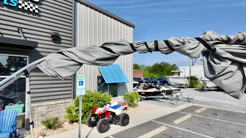 Slide: The Image of Outdoor scene with Yamaha SX190 boat, ATV, and parking lot near a building. - 13