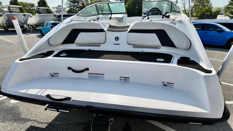 Slide: The Image of 2015 Yamaha Boats SX190, rear view, white and black design, parked outdoors. - 6