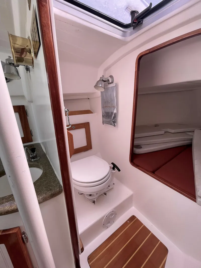Slide: The Image of 2008 Schock Harbor 25 boat interior with compact bathroom and sleeping area. - 10