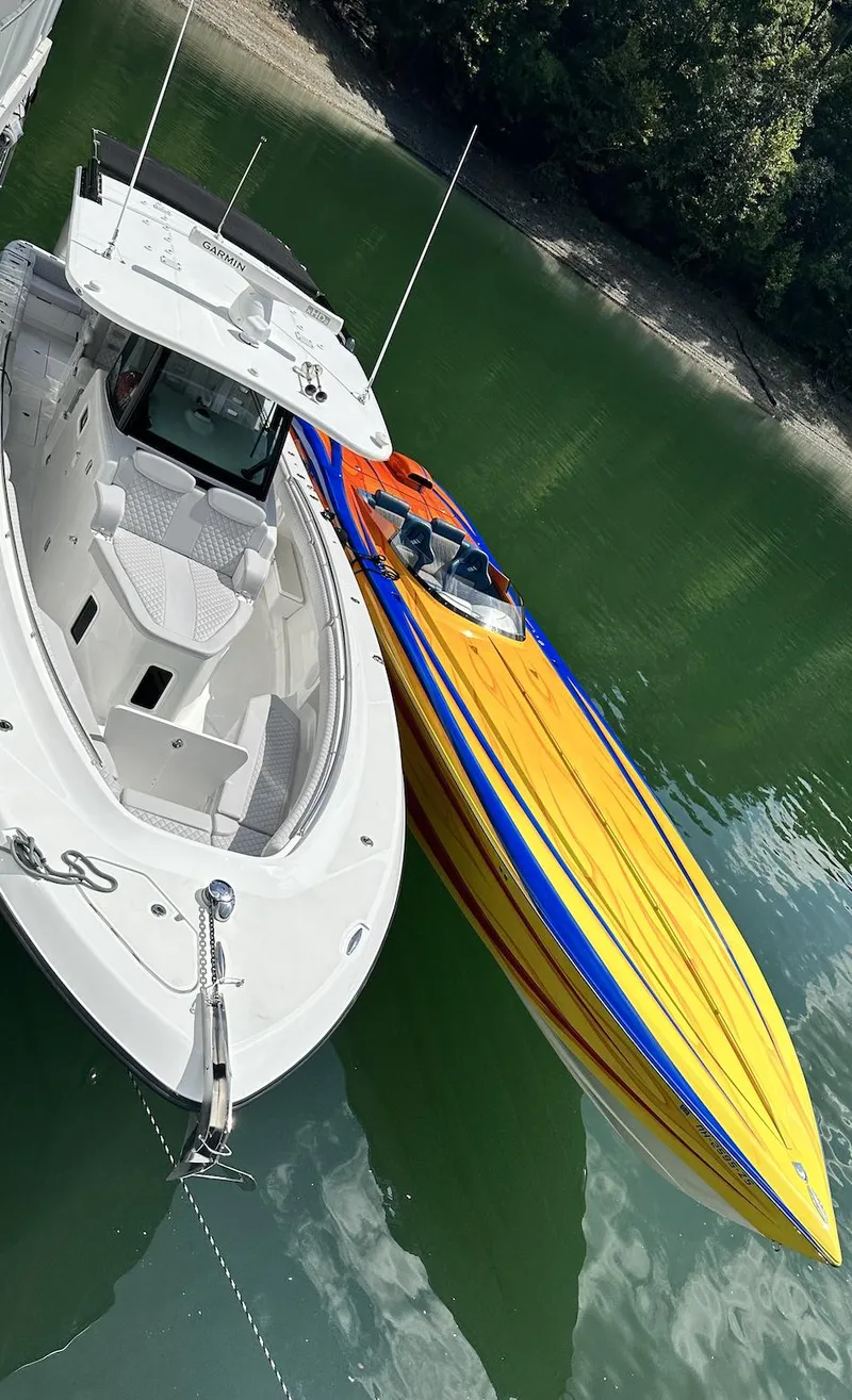Slide: The Image of Two boats docked on calm water, featuring a 2003 Outerlimits 42 GTX. - 11