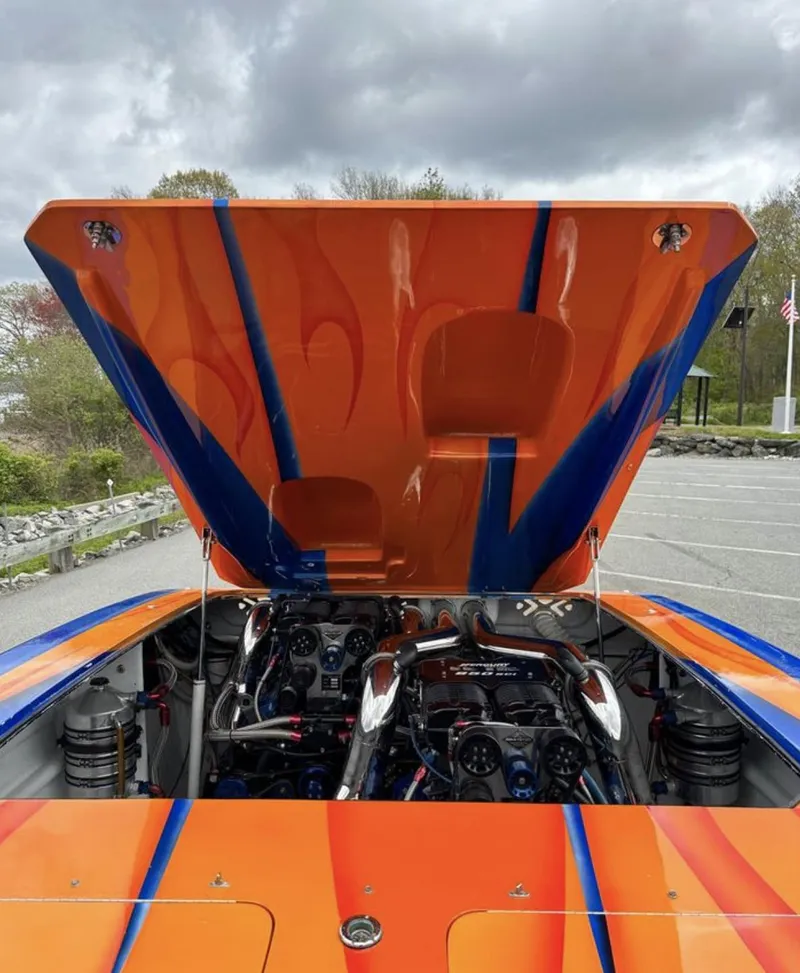 Slide: The Image of 2003 Outerlimits 42 GTX with hood open, showcasing engine and vibrant orange-blue paint. - 4