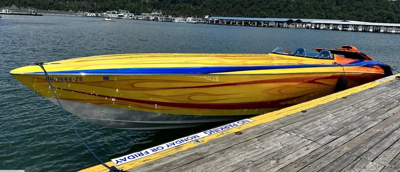 Slide: The Image of 2003 Outerlimits 42 GTX speedboat docked, vibrant yellow and orange paint job. - 9