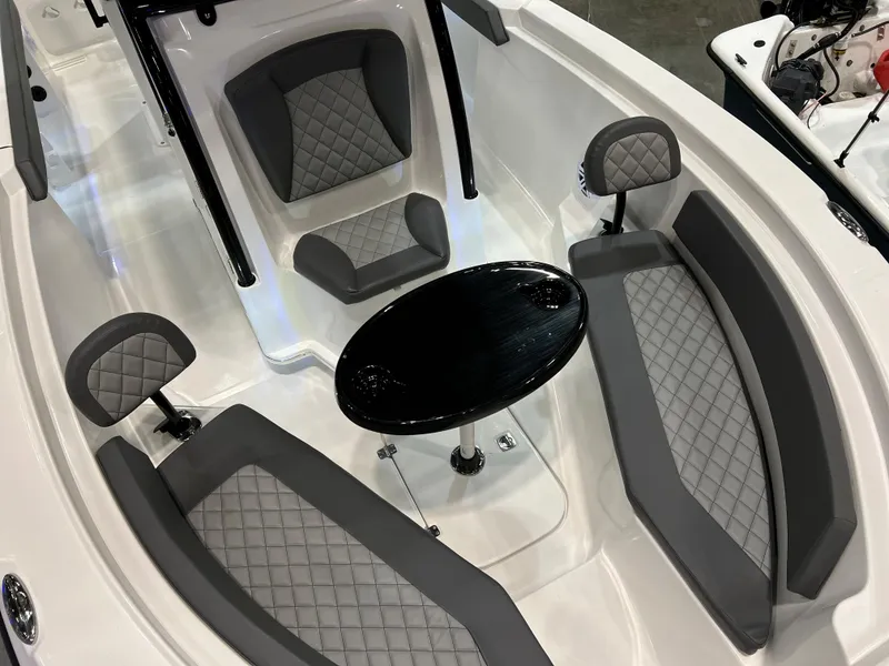 Slide: The Image of 2024 Polar 220 boat interior with gray quilted seats and a black table. - 10