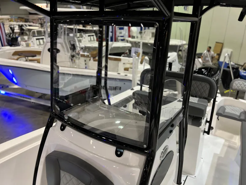 Slide: The Image of 2024 Polar 220 boat at a boat show, featuring a sleek console and seating area. - 9