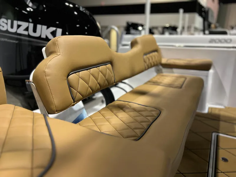 Slide: The Image of 2024 Clearwater 1900 boat with tan diamond-stitched seating and Suzuki engine. - 13