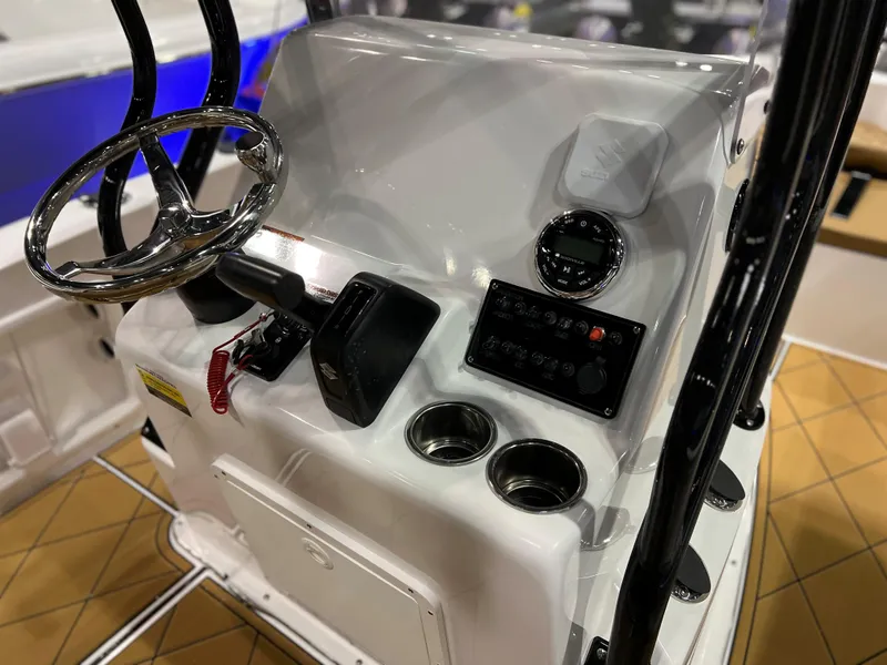 Slide: The Image of 2024 Clearwater 1900 boat console with steering wheel, controls, and cup holders. - 19