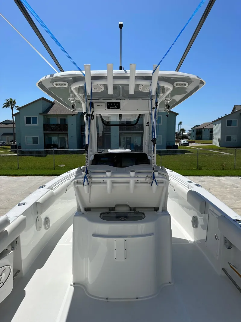 Slide: The Image of 2018 Sea Hunt GAMEFISH 27 CB center console boat docked in a residential area. - 2