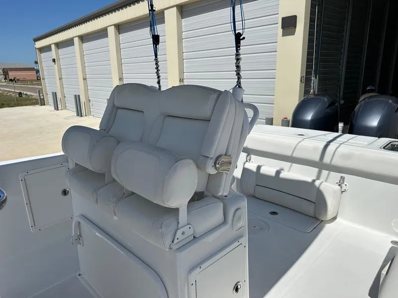 Slide: The Image of 2018 Sea Hunt GAMEFISH 27 CB boat with white cushioned seating and storage compartments. - 4