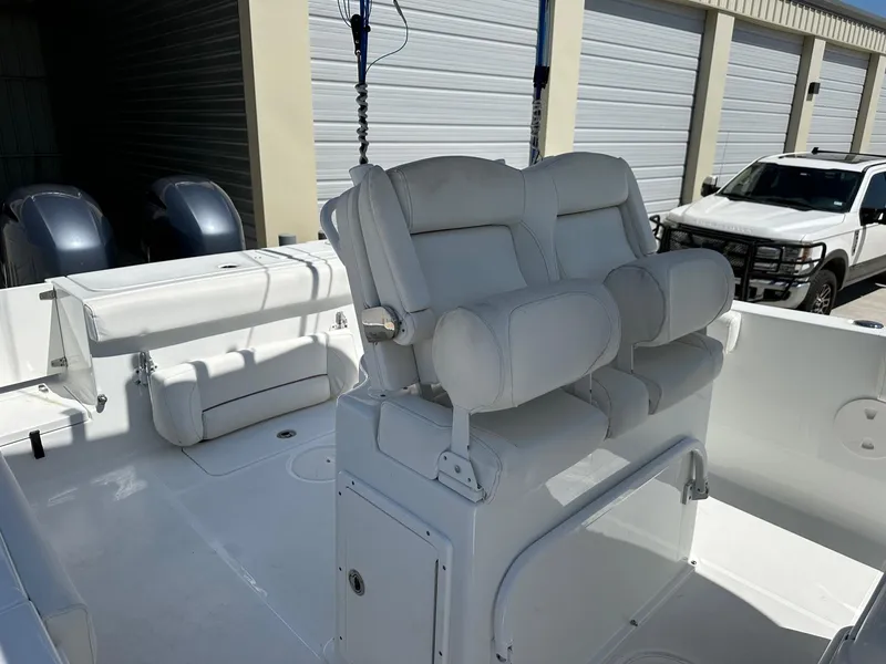 Slide: The Image of 2018 Sea Hunt GAMEFISH 27 CB boat interior with white cushioned seating and dual outboard motors. - 5