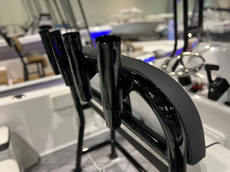 Slide: The Image of Close-up of 2024 Clearwater 2000 boat's black rod holders and steering console. - 10