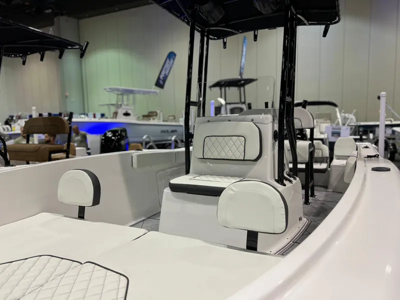 Slide: The Image of 2024 Clearwater 2000 boat interior with white cushioned seats at a boat show. - 5